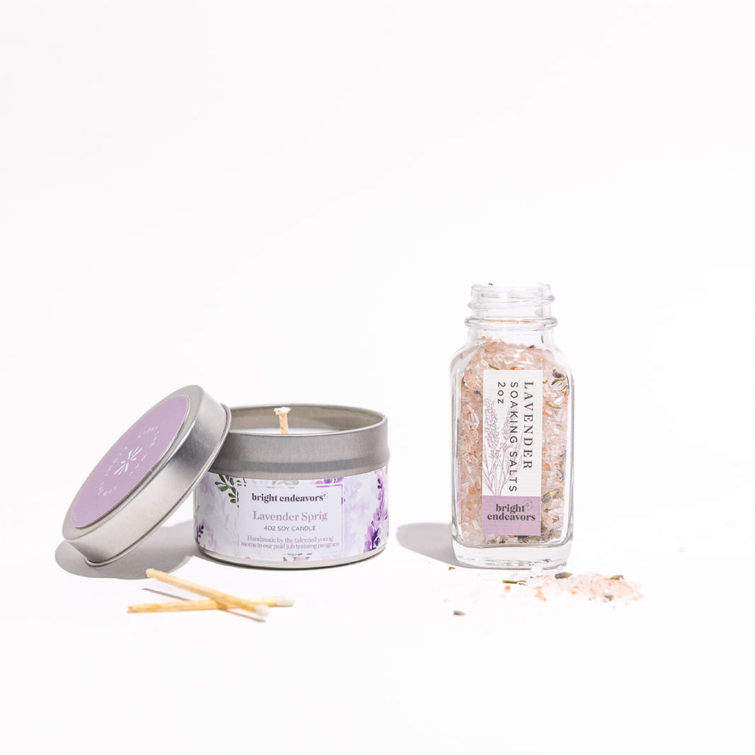 Candle, bath salts, and a bottle of essential oils on a white background