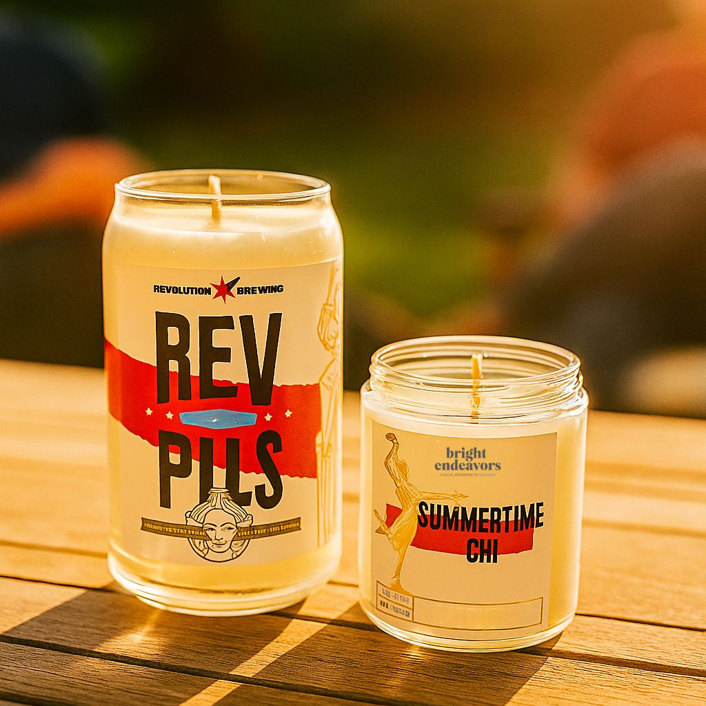 Two candles with labels on a wooden surface outdoors