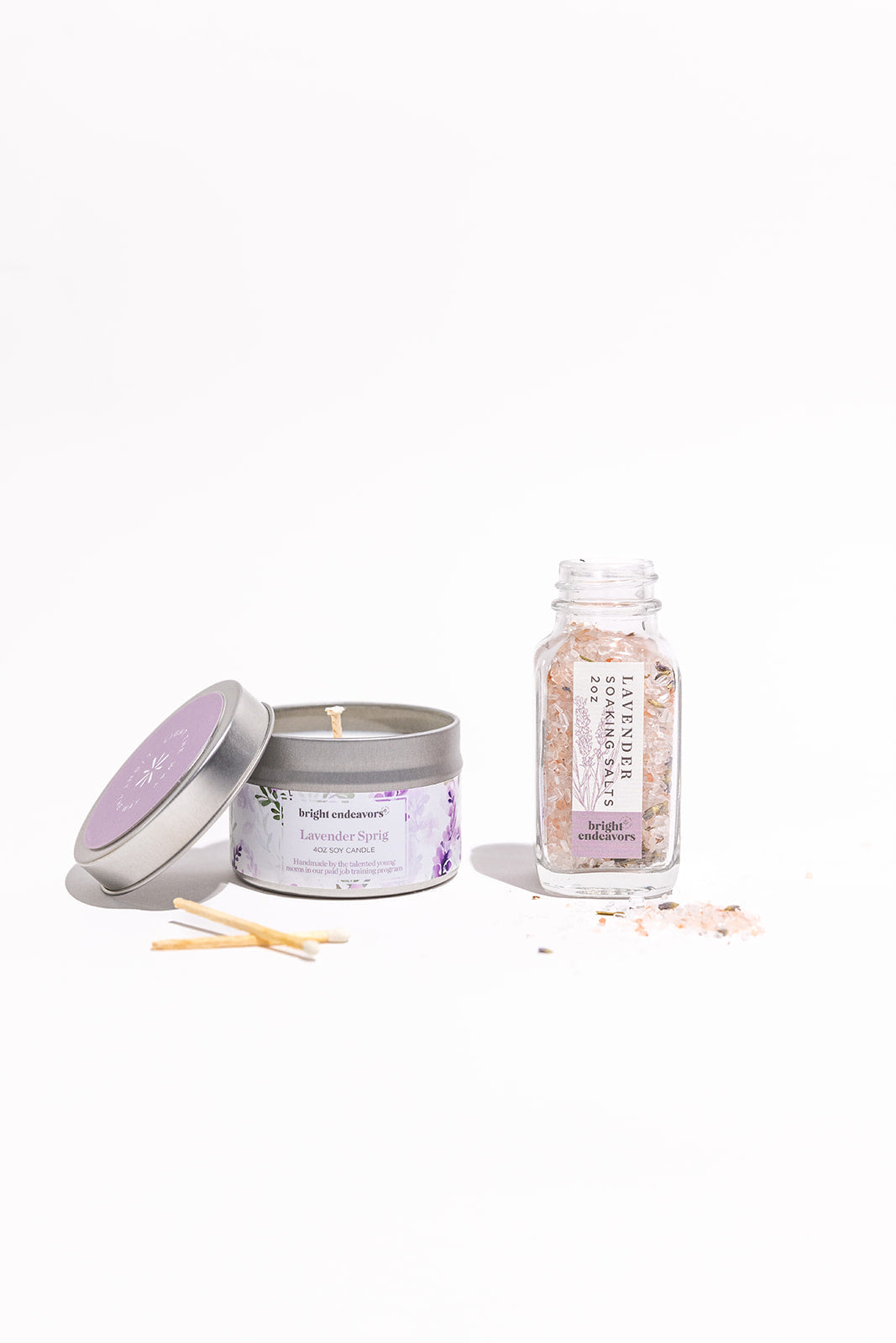 Candle, bath salts, and a bottle of essential oils on a white background